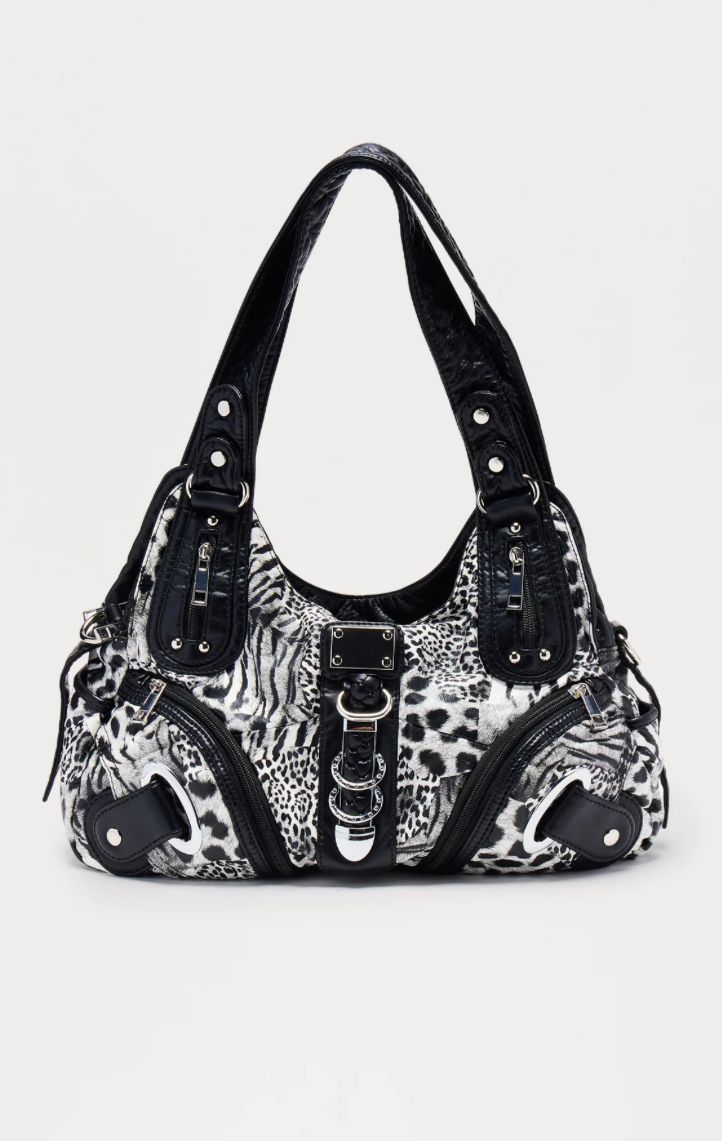 Black and white patterned handbag with decorative elements on a light gray background