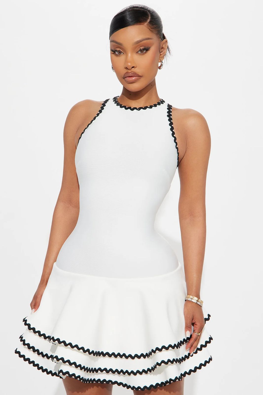 Woman wearing a white dress with black trim on a white background